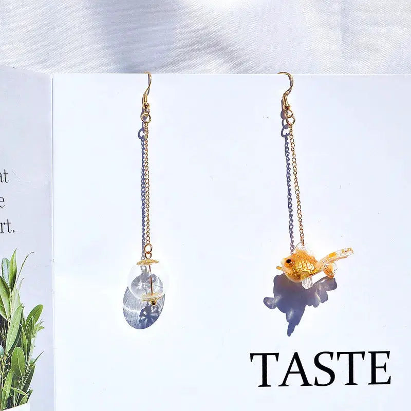 Simples Market goldfish drop earrings; pair with a clear oval pendant on one and an orange koi fish charm on the other