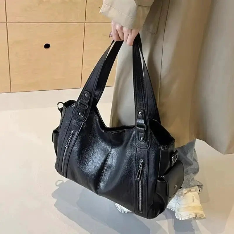 Black PU leather shoulder bag with soft interior compartments, dual top handles, and exterior zip pockets
