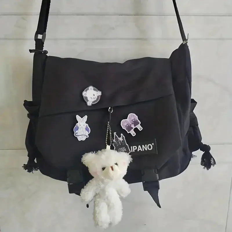 Men's black nylon crossbody bag with patches and a white plush teddy keychain