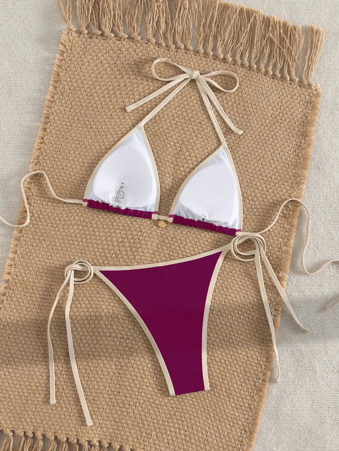 Two-piece bikini set with white triangle top and purple color-block bottom, beige trim and tie sides