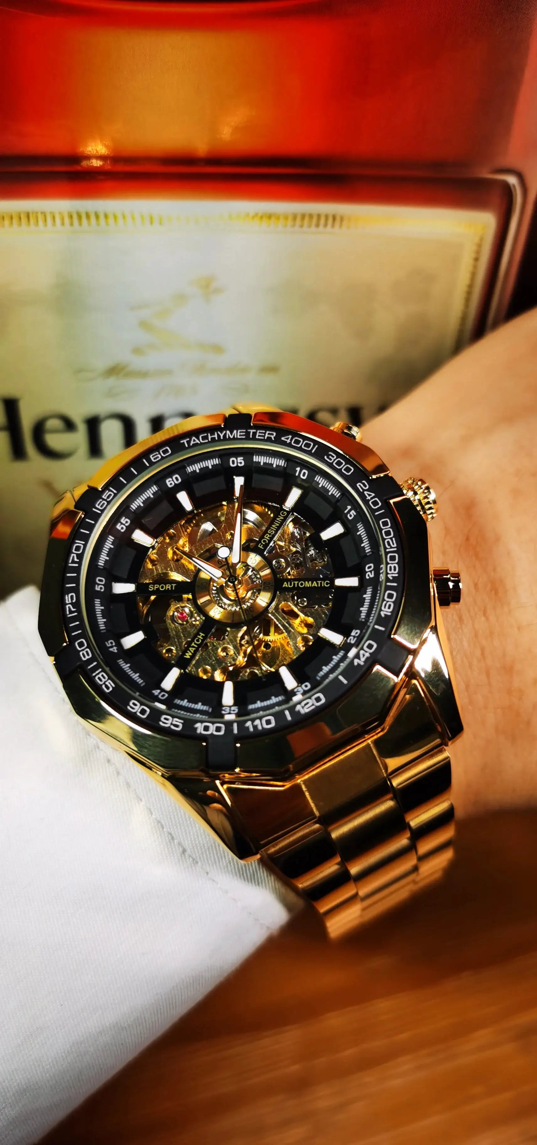 Forsining men's skeleton automatic watch with gold stainless steel strap and black tachymeter bezel