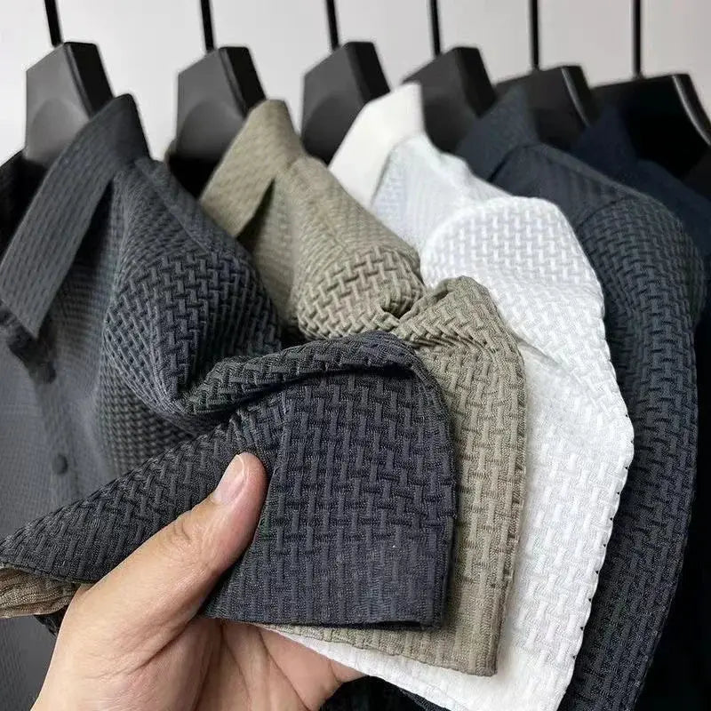 Men's polo shirts on a rack in gray, beige, white and navy; close-up of textured woven fabric.