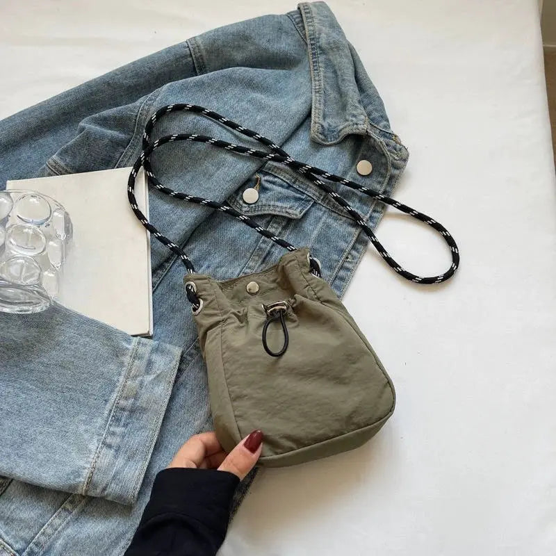 Simples Market nylon crossbody bag, olive compact square purse with black-and-white rope strap.
