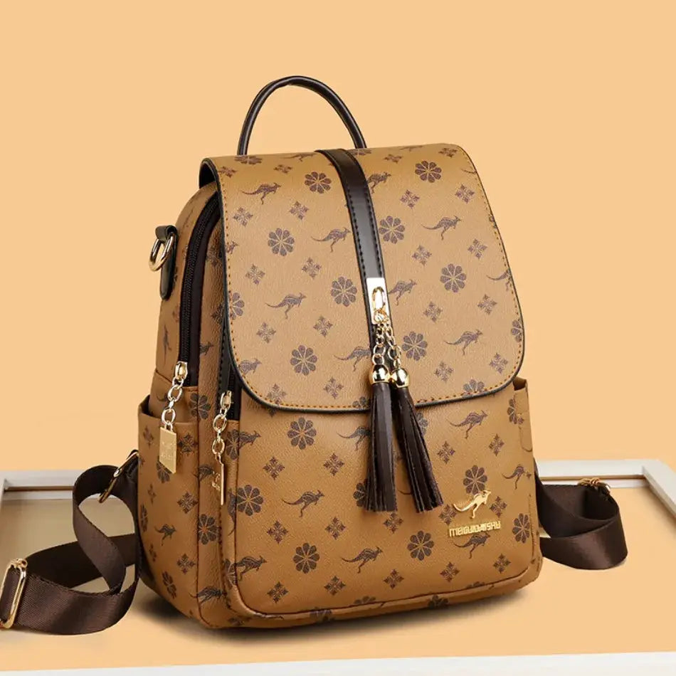 Ladies leather backpack with tan floral print, tassel charms, top handle, large capacity