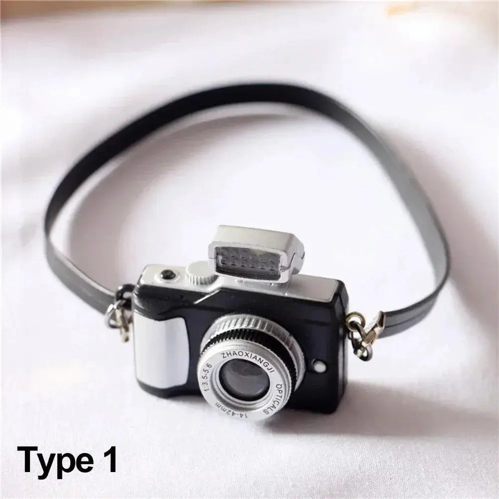 Dollhouse miniature black and silver digital SLR camera with strap