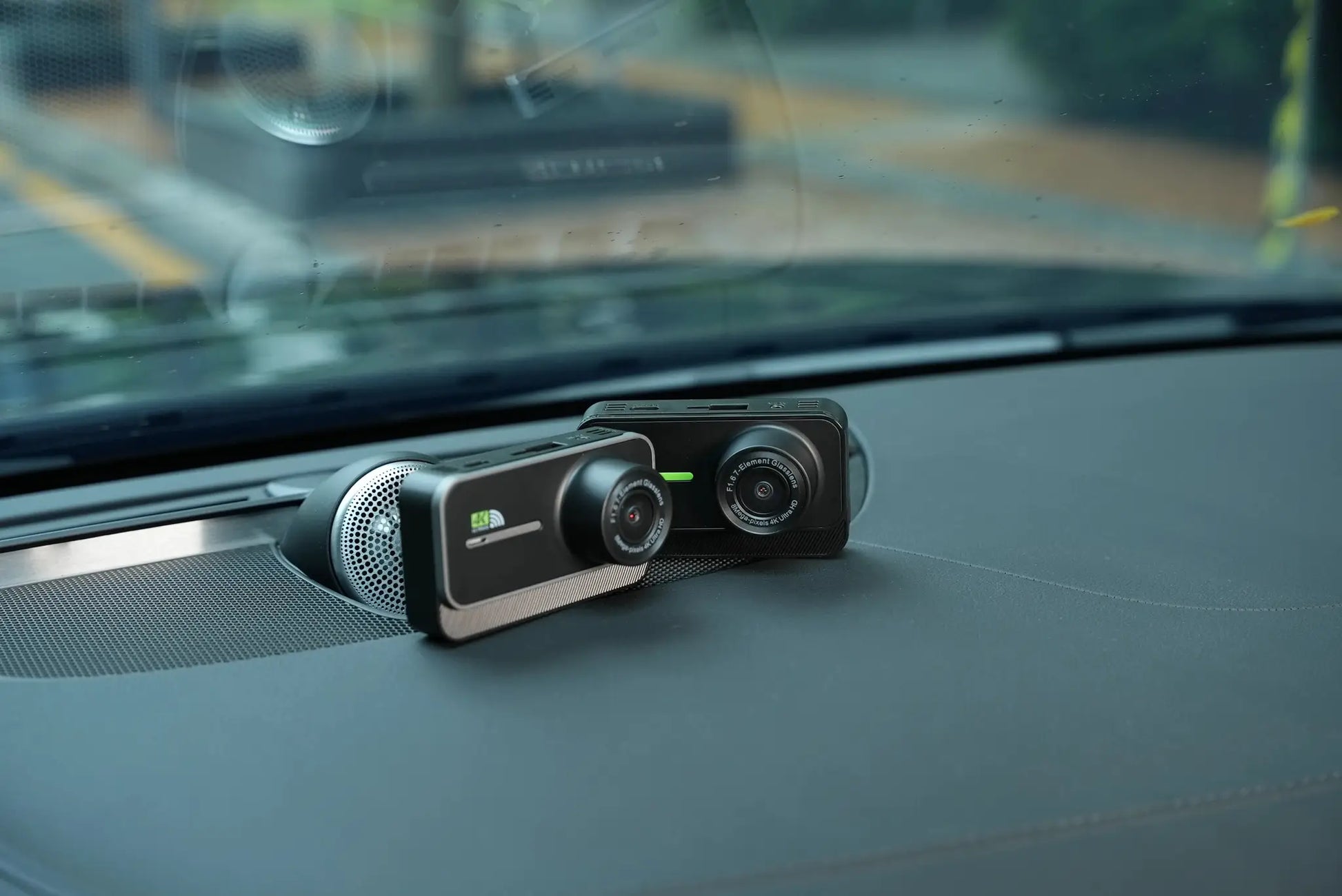 4K dash cam with front and rear lenses in black mounted on car dashboard