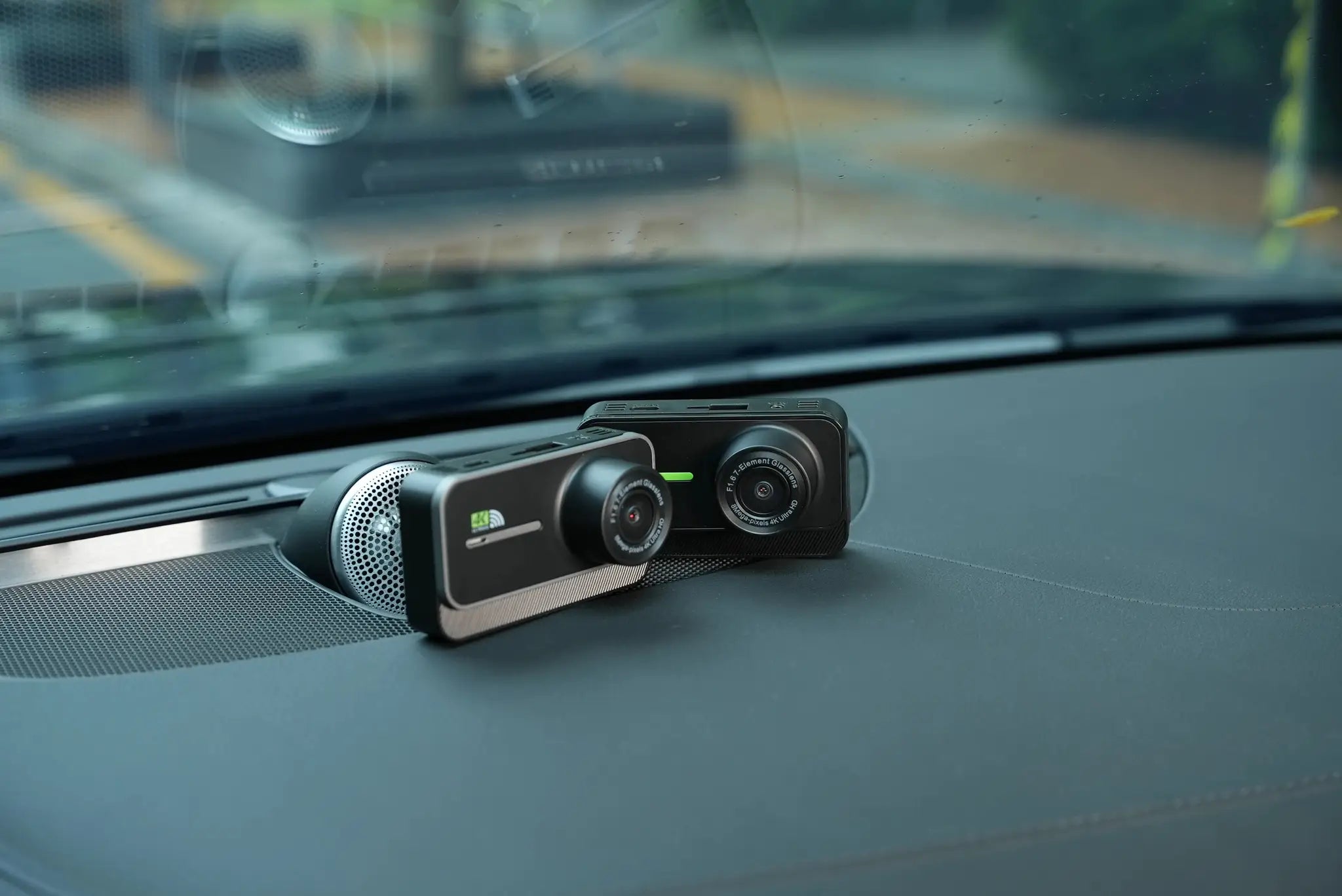 4K dash cam with front and rear lenses in black mounted on car dashboard