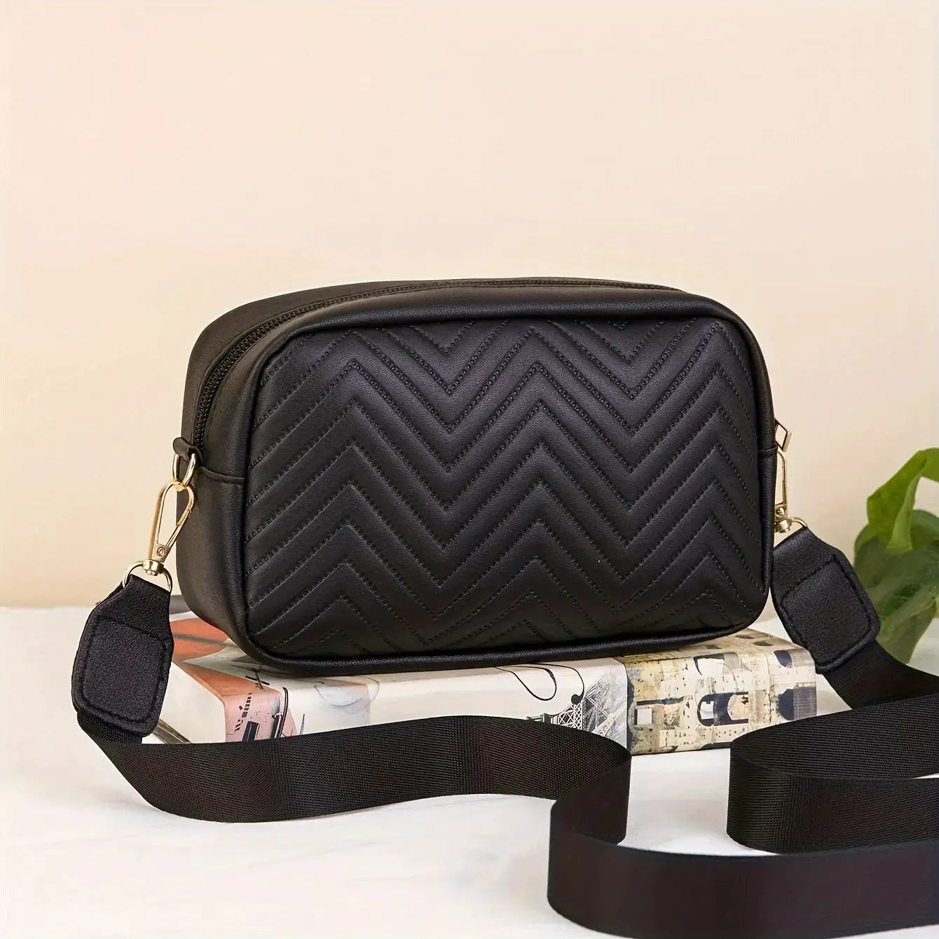 Quilted black PU leather crossbody bag with gold-tone hardware and adjustable strap.