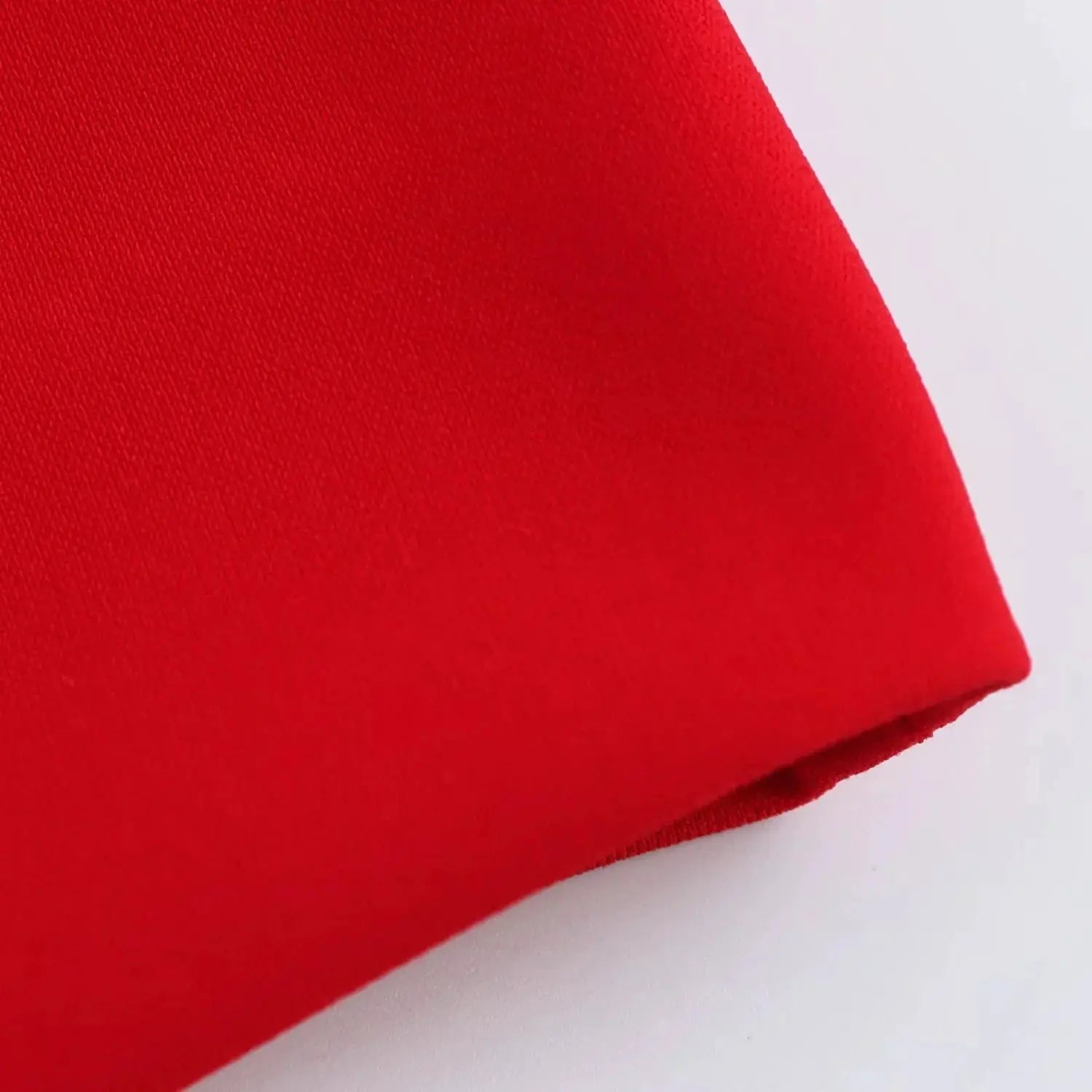KONDALA red sleeveless blazer fabric close-up showing hem edge and texture