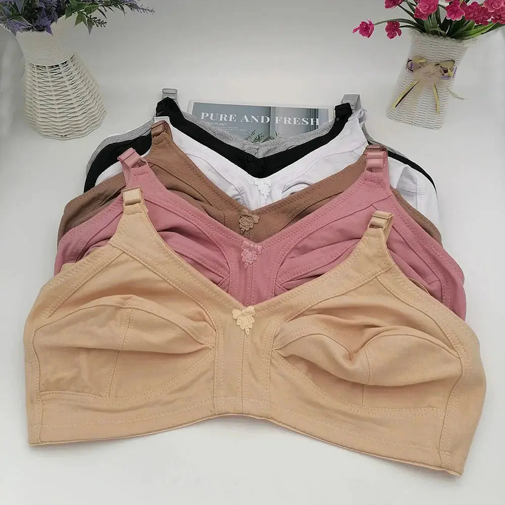 Push-up seamless bras, five plus-size bras in nude, pink, brown, white and black on hangers.