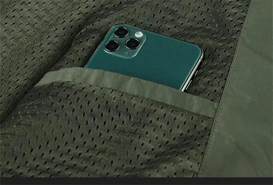 Sleeveless cargo vest in olive green with breathable mesh fabric; phone tucked in front pocket