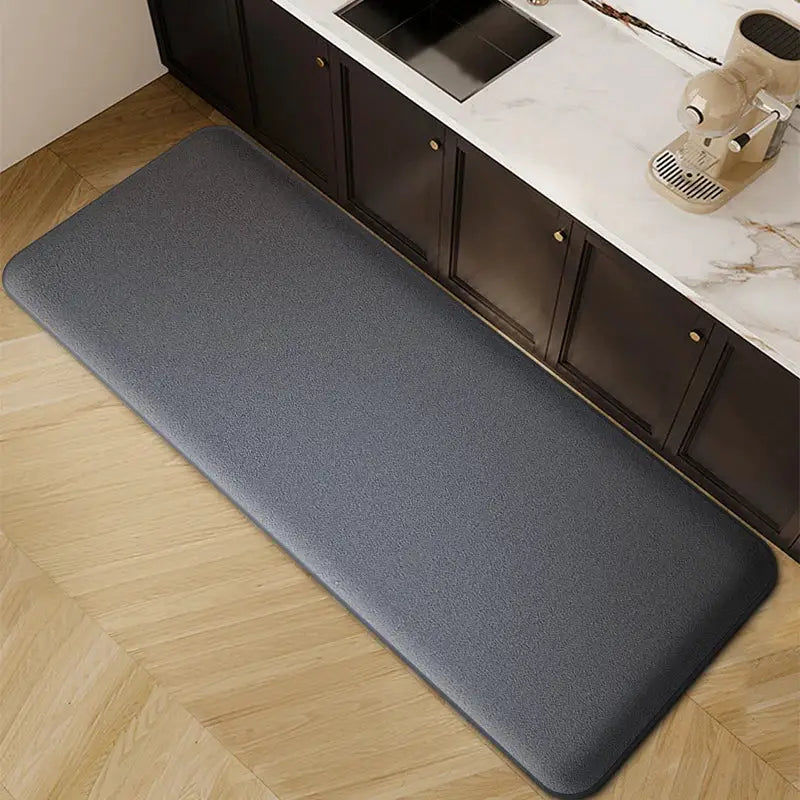 Gray long kitchen floor mat with a textured surface and non-slip grip along cabinets.