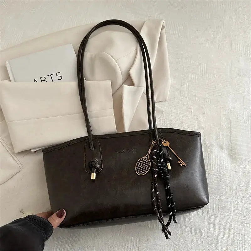 Simples Market dark brown tote bag with long handles and decorative pendant charms.