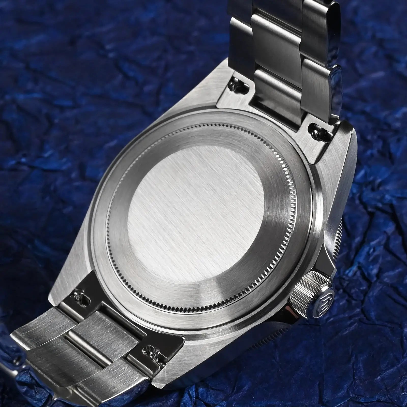 Watchdives WD1969 Pro stainless steel 38mm watch with brushed case back and linked bracelet against a blue background