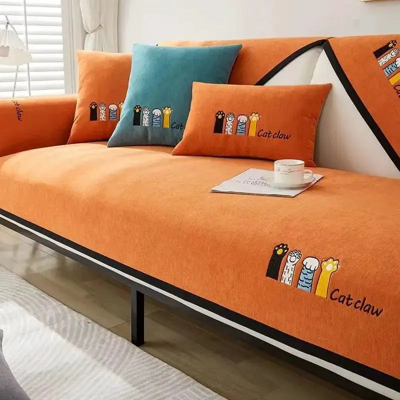 Chenille sofa cover with orange cushions and teal accent pillow, Catclaw design.