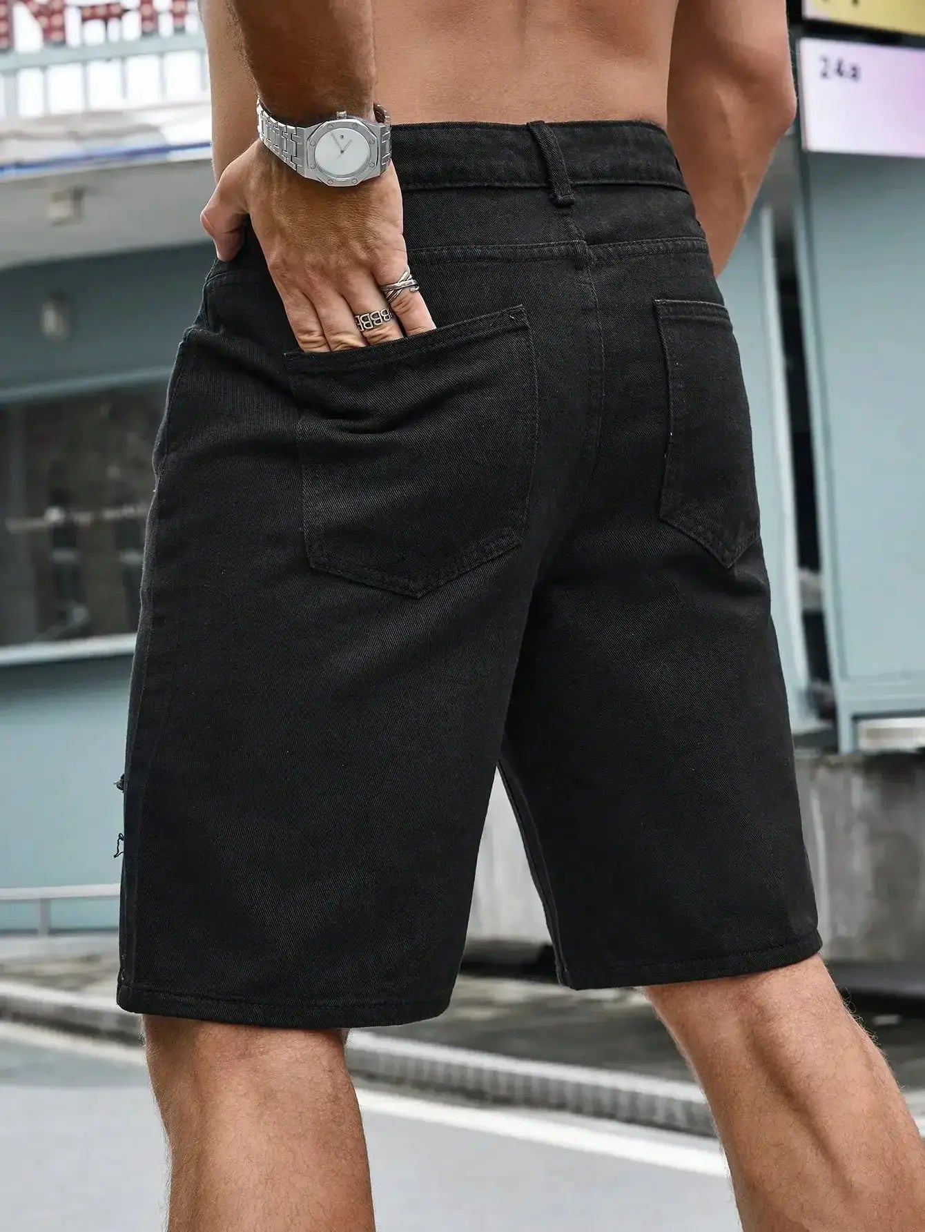 Men's black denim shorts with back pockets and belt loops, knee-length casual shorts.