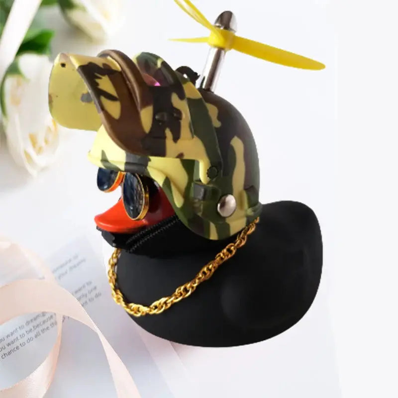 Camouflage helmeted yellow rubber duck car ornament with propeller, perched on a black hat base with a gold chain