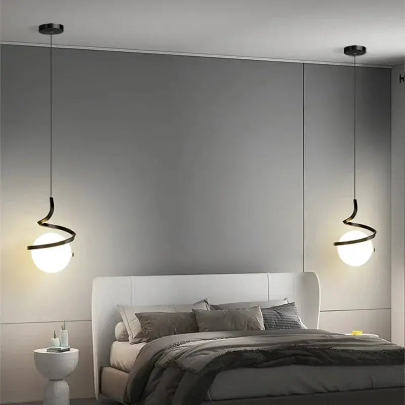 Nordic LED pendant lights by Simples Market, pair of spiral black metal fixtures with globe bulbs over a bed.