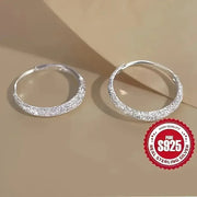 Two frosted sterling silver hoop earrings with a textured surface and S925 stamp