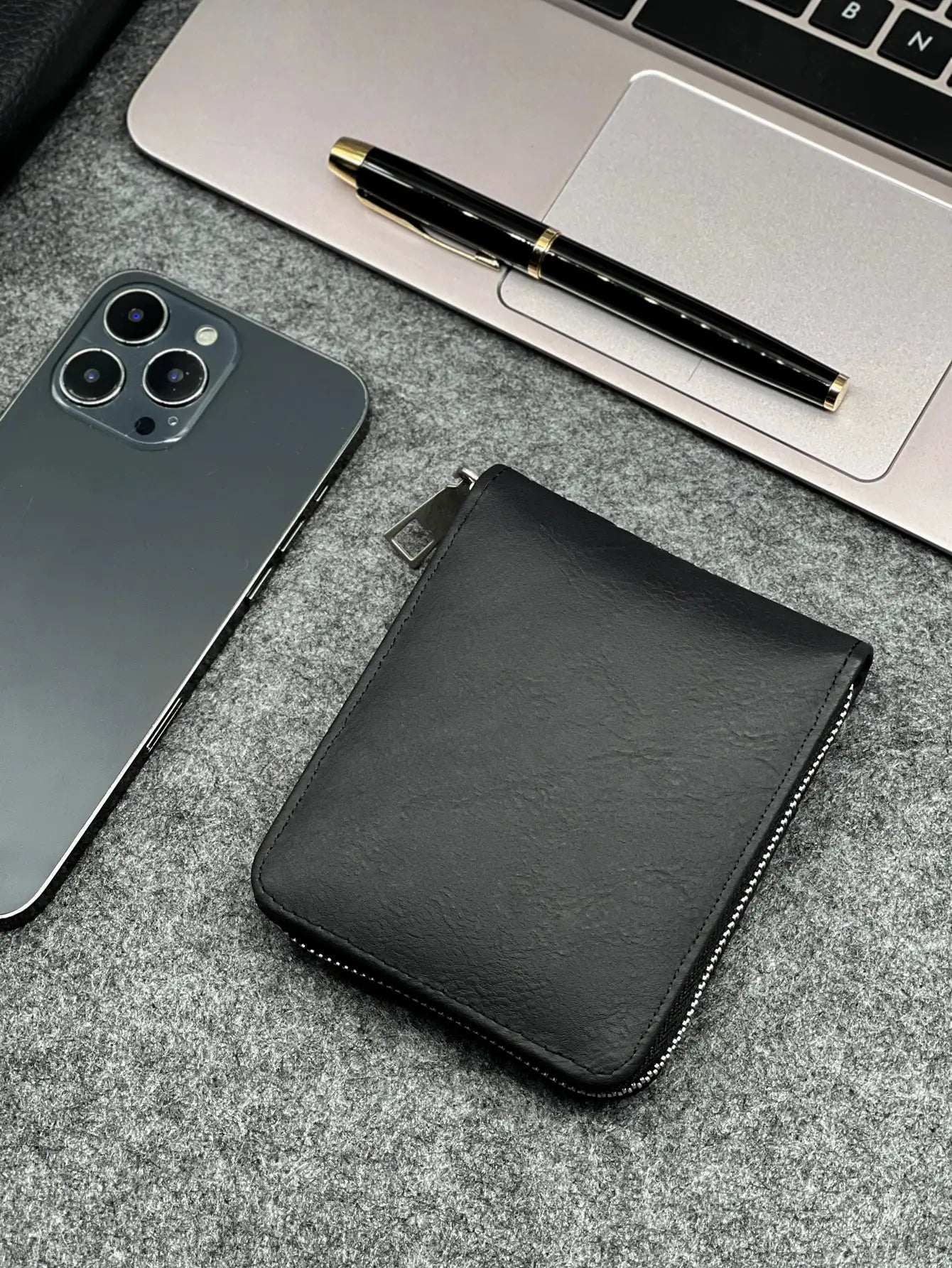 Zippered slim PU wallet in black; compact design for coins and cards.