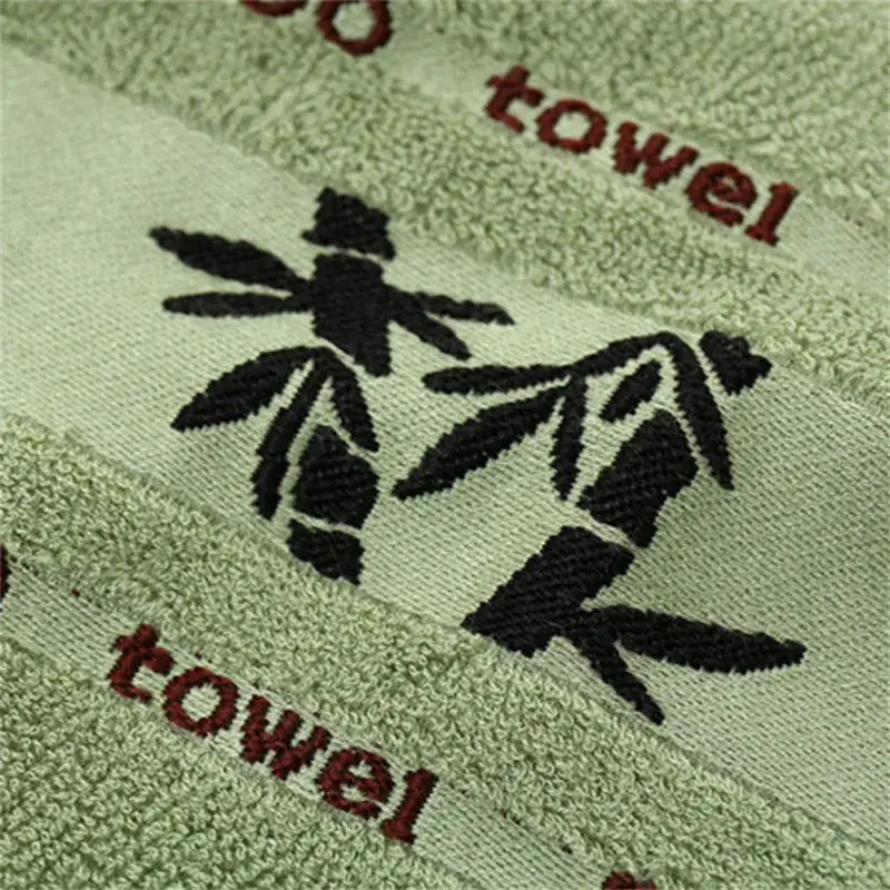 Set of 2 green bamboo fiber towels with black bamboo graphic and red text