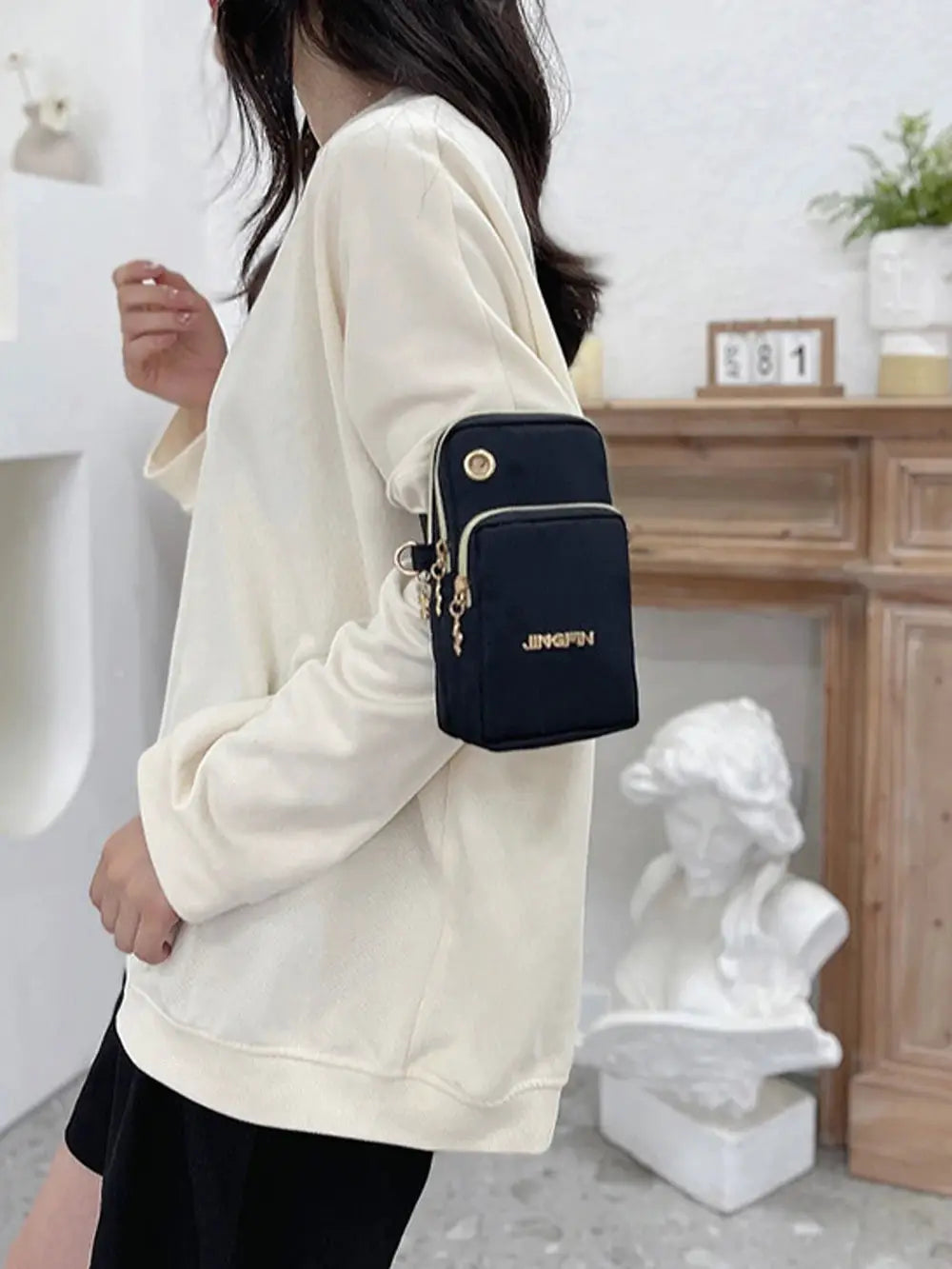 Mobile phone crossbody mini bag in black with gold hardware and front pocket