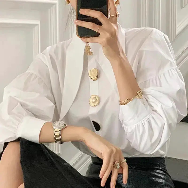 White pearl-button blouse with oversized long sleeves and gold-tone buttons by Simples Market