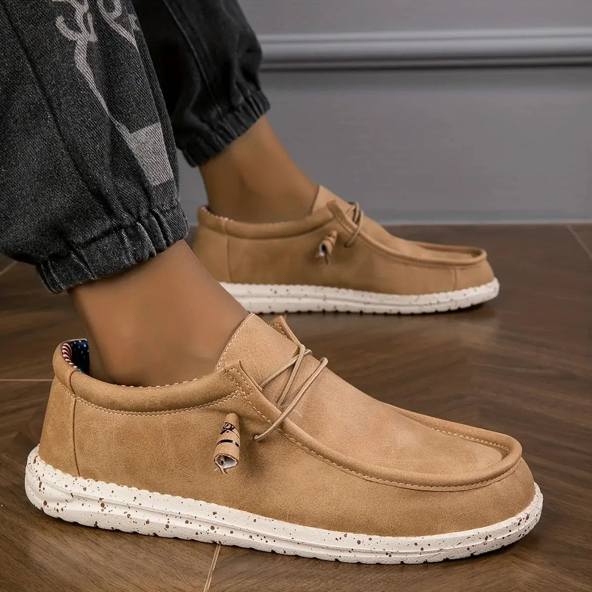 Pair of men's tan slip-on loafers with white speckled sole for casual wear.