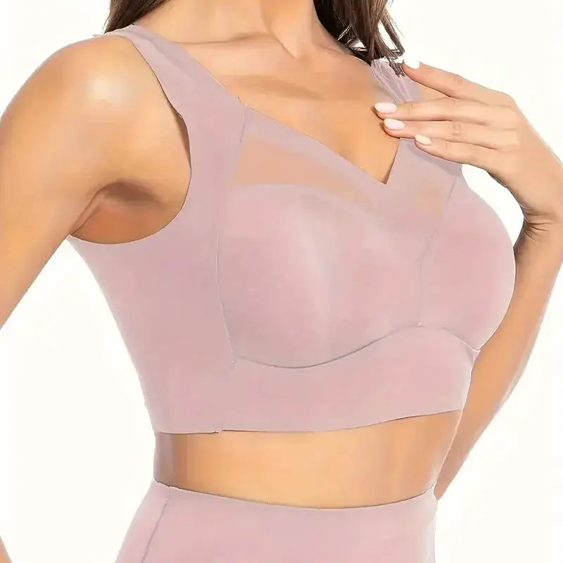 Women's seamless pink sports bra with padded cups and mesh panels