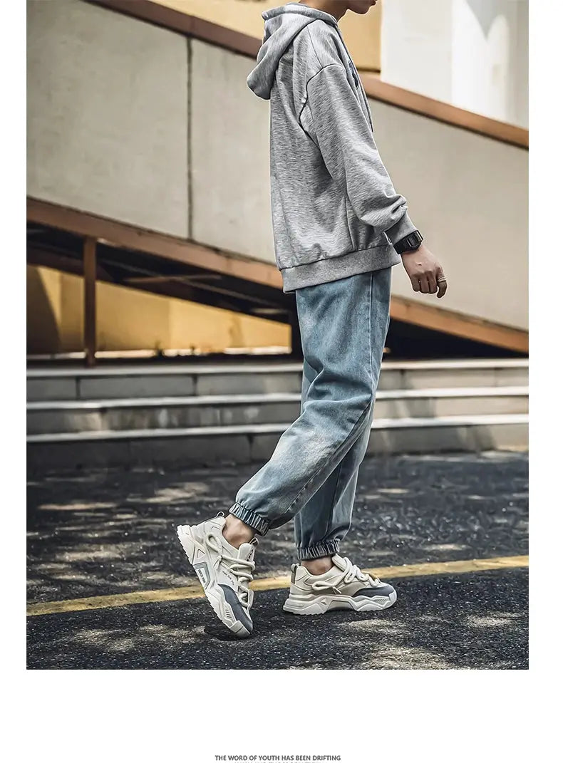 Men's casual sneakers, cream-white with chunky sole, shown with gray hoodie and light-blue joggers