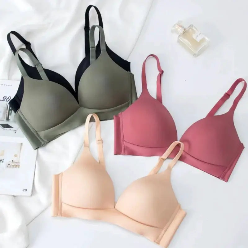 Four seamless wireless bralettes in olive/gray, black, pink & nude on a white background