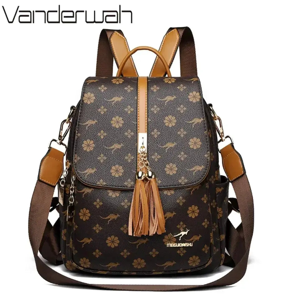 Ladies leather backpack by Vanderwah with brown floral print, tan leather trim, tassel zipper, and top handle.