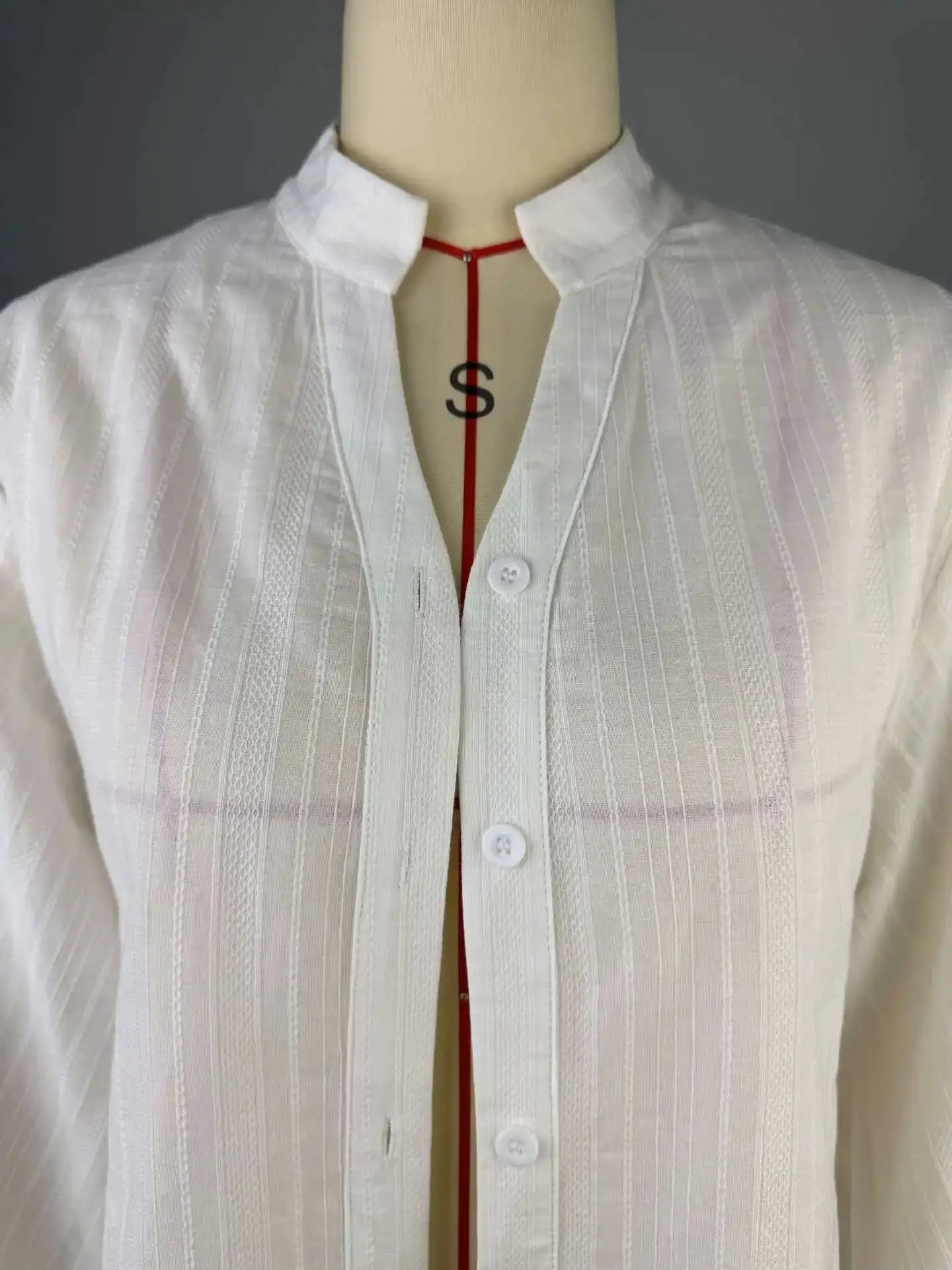Oversize white cotton shirt for women with long sleeves, button-up front and subtle vertical stripe texture.