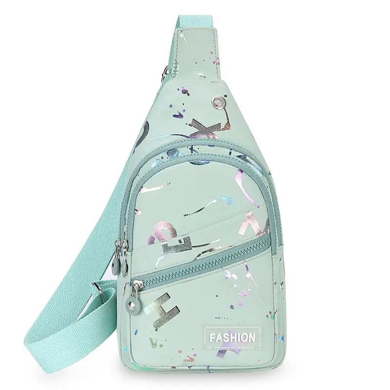Chest bag crossbody sling backpack in mint green with abstract print and front zip pockets.