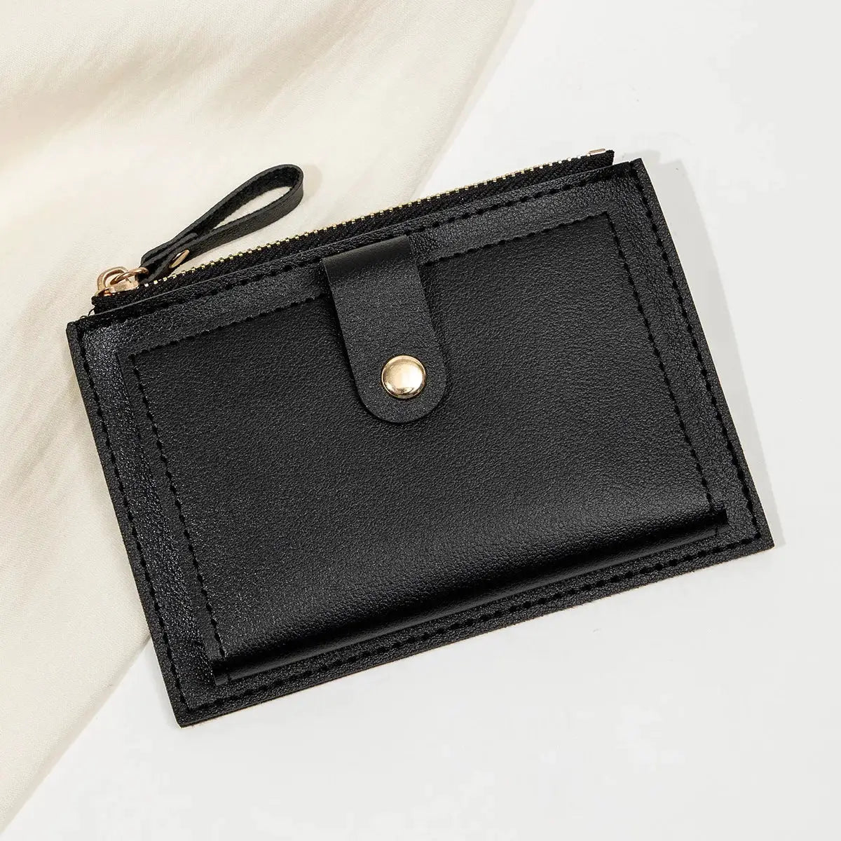 Minimalist black PU leather mini card wallet by Simples Market, with zip closure and snap strap