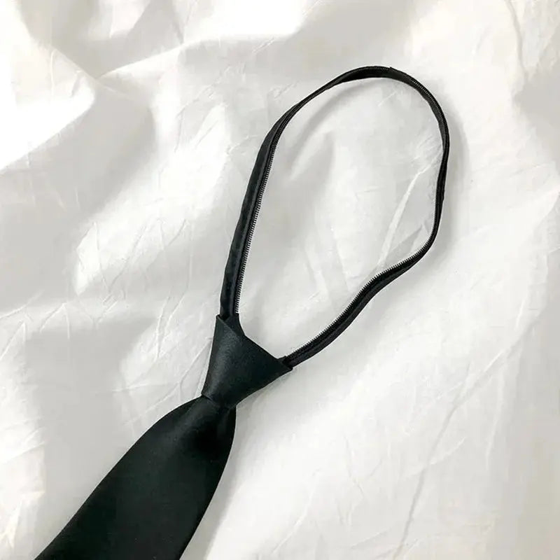 Black necktie on elastic loop with knot, close-up on white background