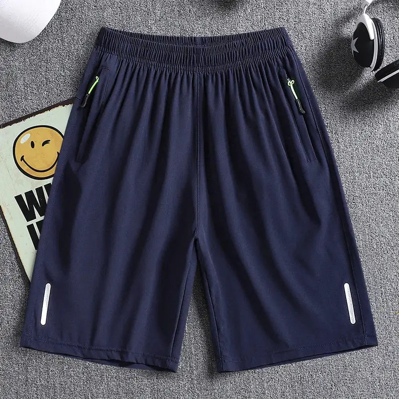 Men's navy athletic shorts with elastic waist, zip pockets, and reflective trims