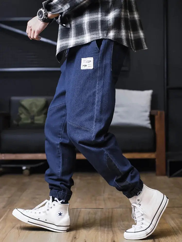 Plus size men's loose jogger jeans in dark blue denim with cargo pockets and elastic ankle cuffs
