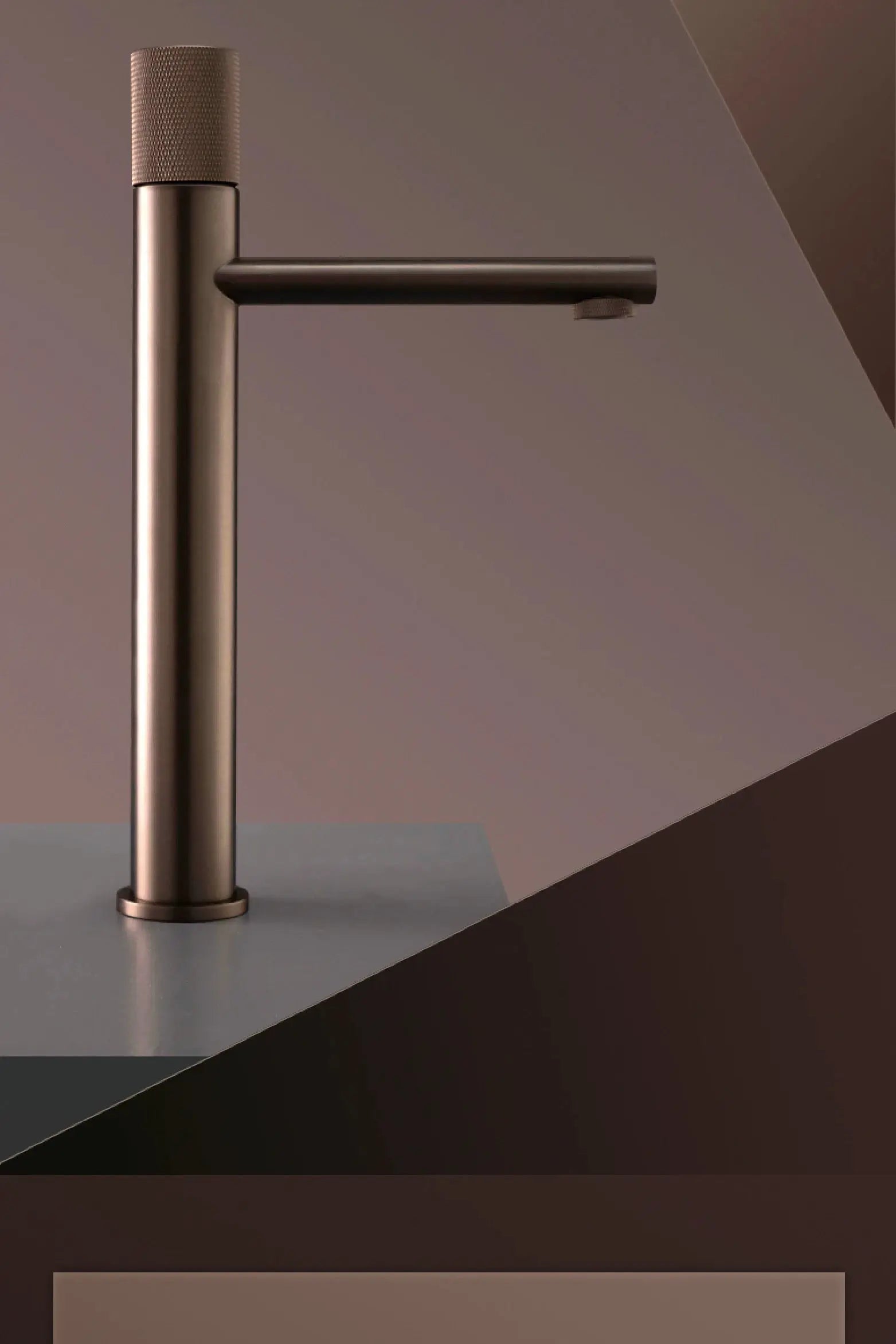 Brass-black bathroom faucet with tall cylindrical body and horizontal spout on a countertop.