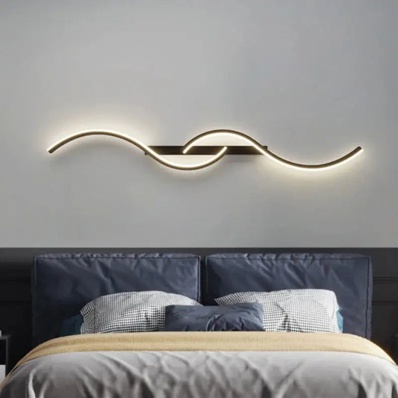 Modern LED wall lamp with black metal mount and curved light strip, warm white glow