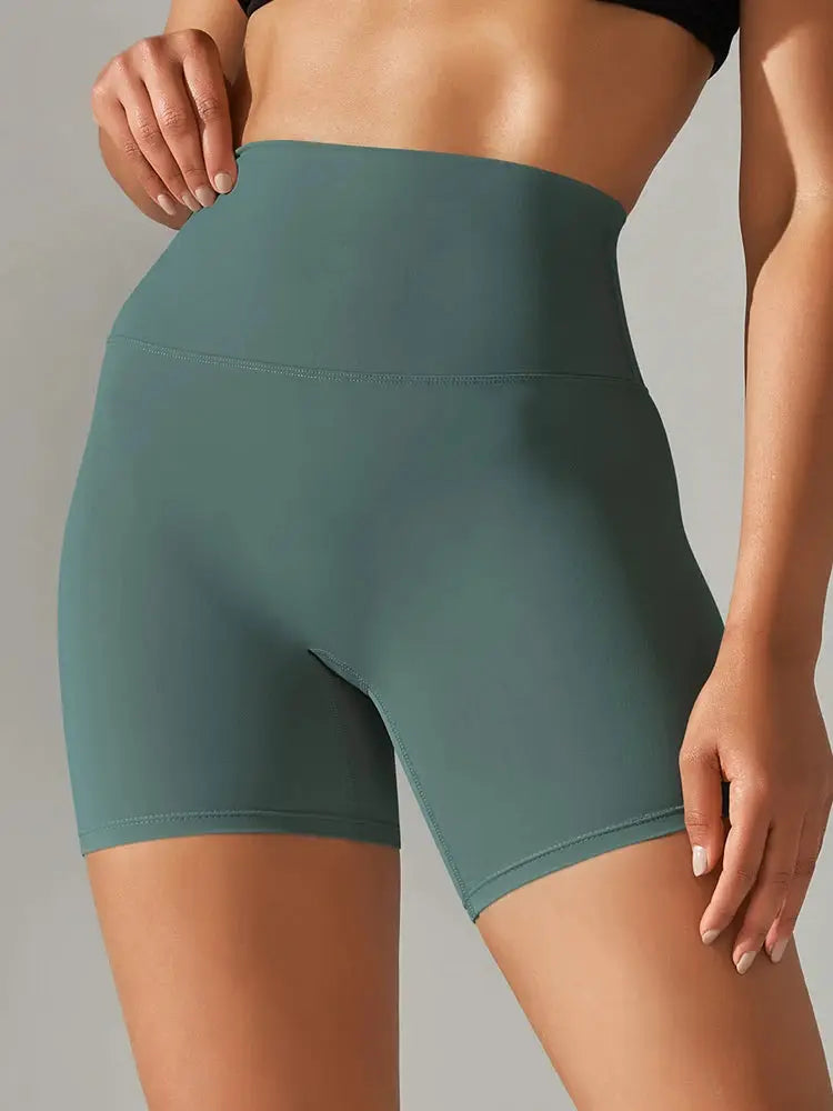 Women's teal high-waisted yoga shorts with a tight athletic fit for workouts