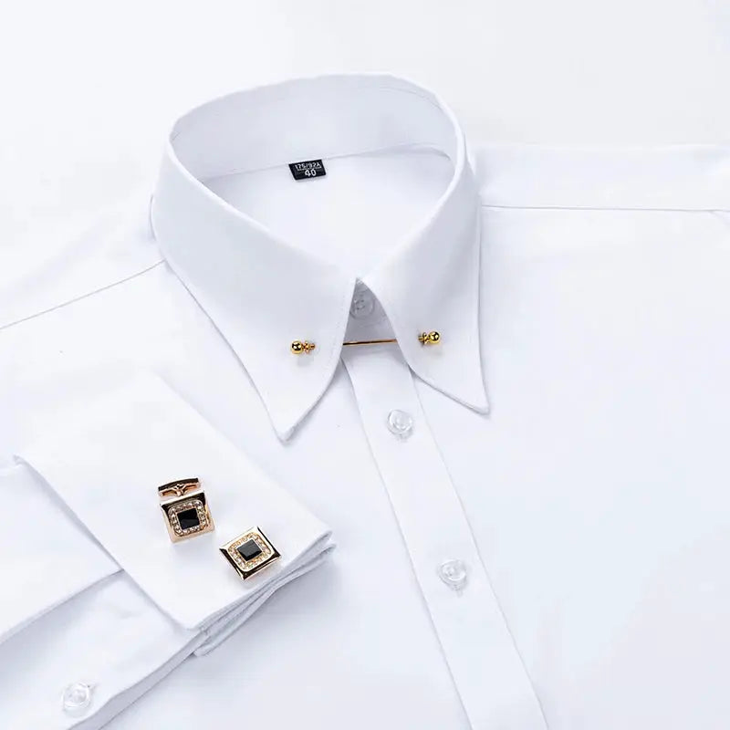 White dress shirt with gold-tone collar pins and square cufflinks with black centers.