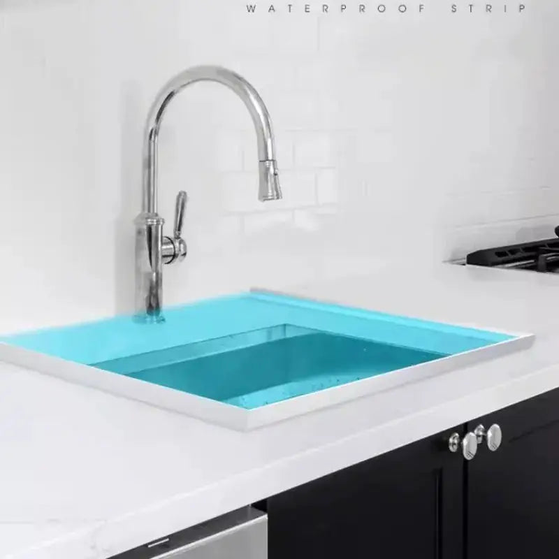 Kitchen water retaining strip; chrome faucet over a white countertop sink with blue water.