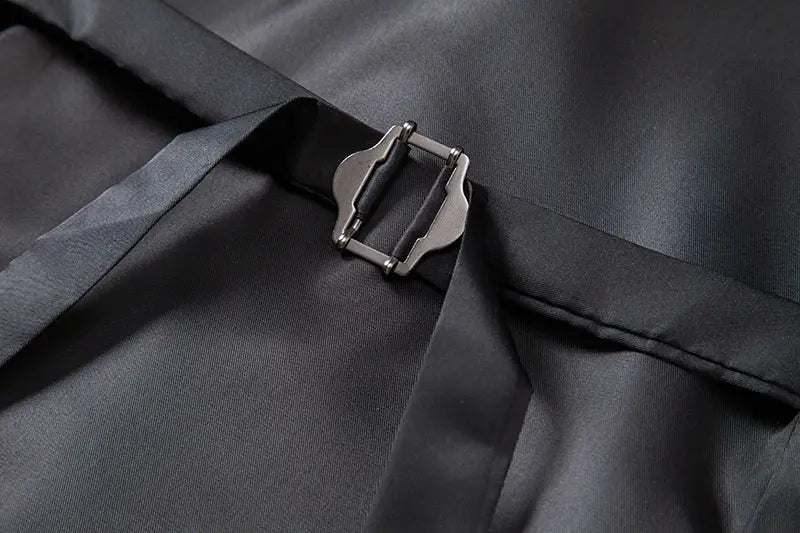 Simples Market waistcoat buckle detail on dark fabric; black adjustable strap with metal clasp