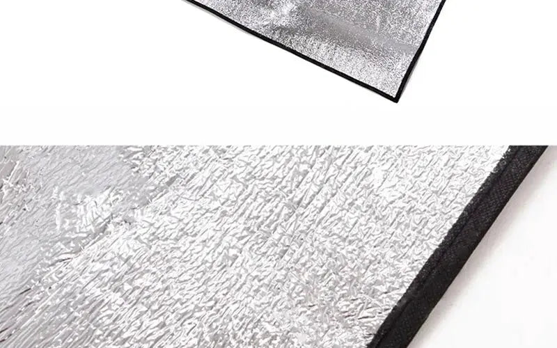 Camping mat with silver reflective foil surface and black edge, foam insulation for outdoor use
