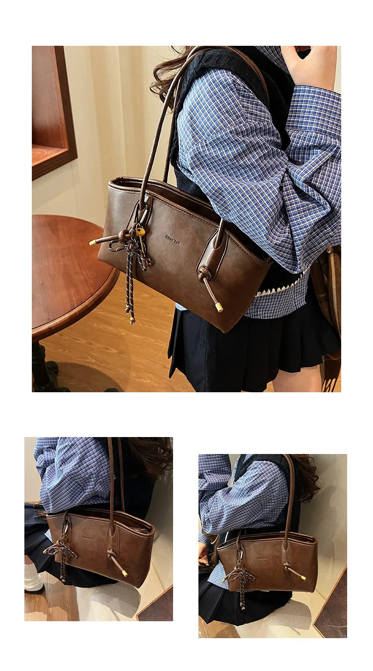 PU leather shoulder bag by Simples Market in brown with tassel charm, carried by a woman in a blue checkered top.