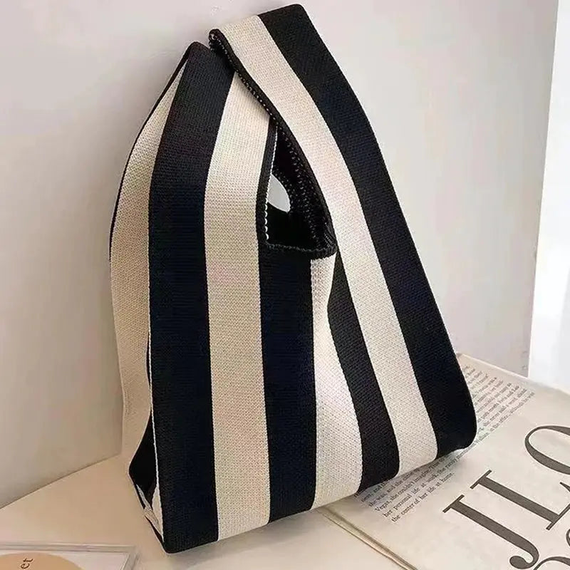 Mini handwoven handbag with black and white vertical stripes and a wide canvas strap.