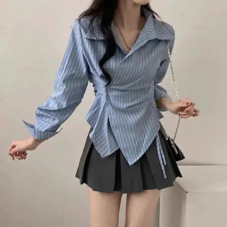Light blue striped wrap shirt with long sleeves and asymmetric hem, two-piece outfit with a black pleated mini skirt