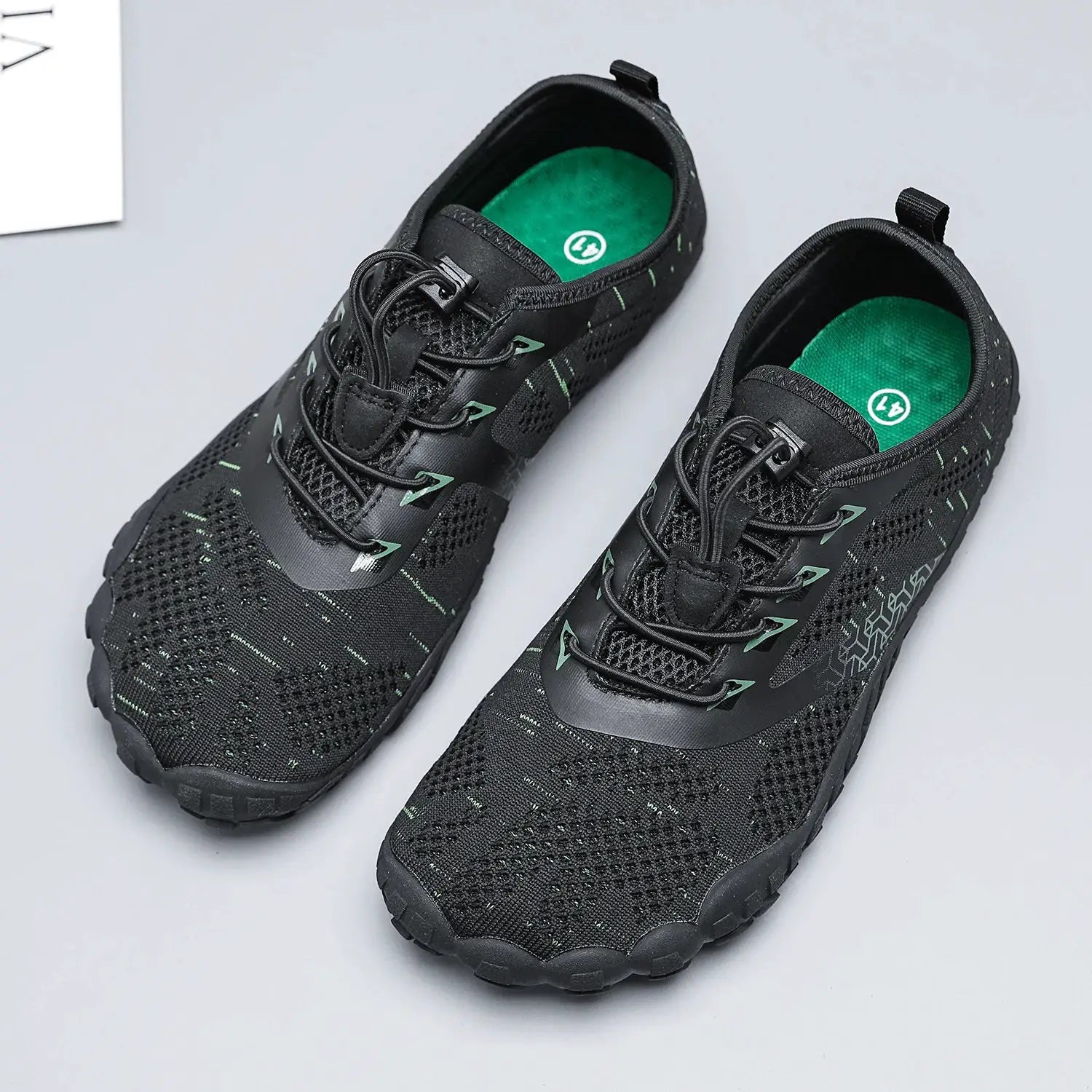 Men's trail running shoes, black mesh upper with green accents and green insoles, pair.