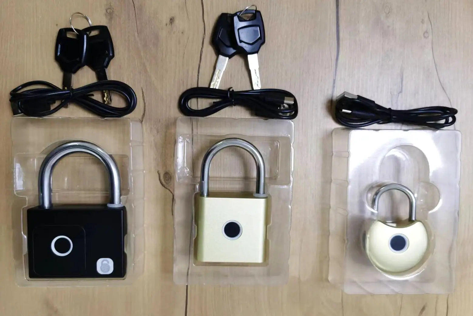 Three fingerprint padlocks with USB charging cables in black, gold, and beige finishes